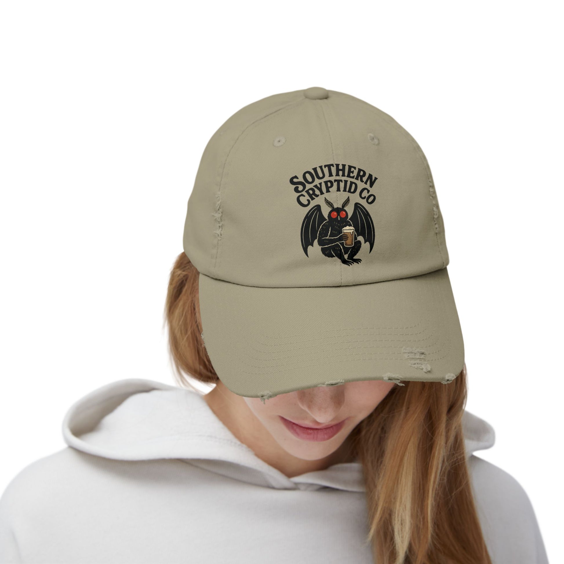Distressed dad hat with Southern Cryptid Co. logo featuring Mothman holding a pint of beer.