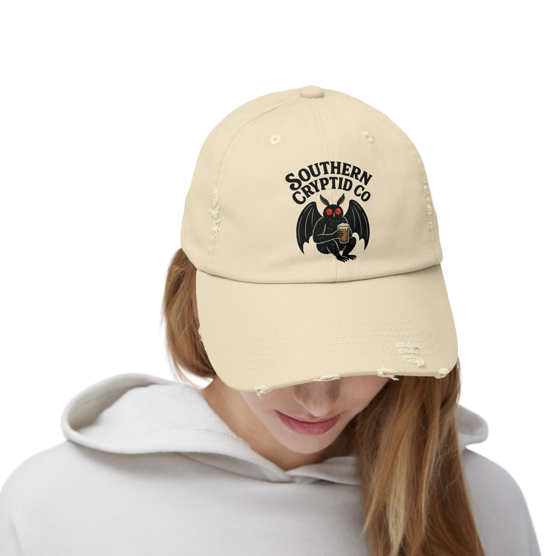 Distressed dad hat with Southern Cryptid Co. logo featuring Mothman holding a pint of beer.