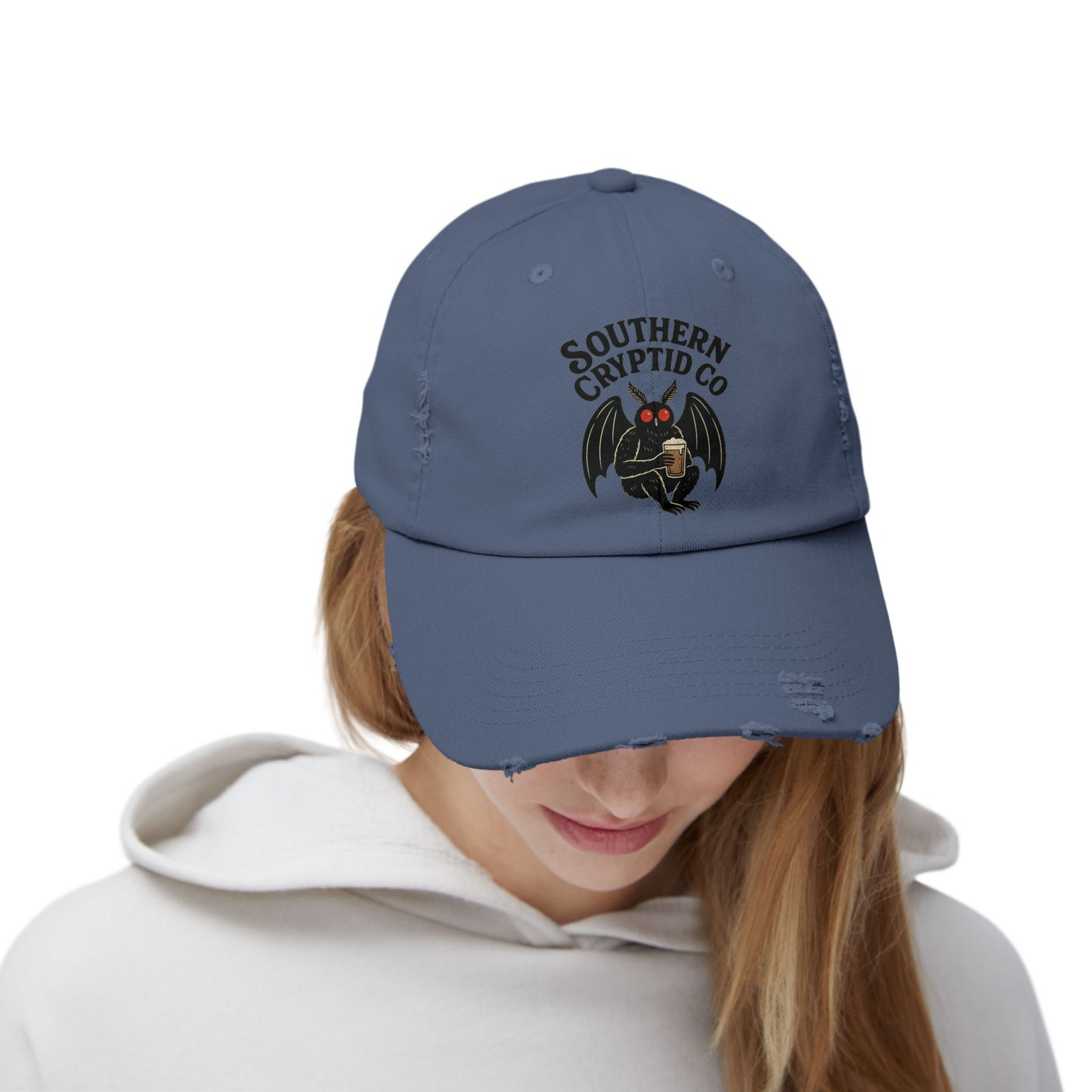 Distressed dad hat with Southern Cryptid Co. logo featuring Mothman holding a pint of beer.